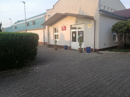 Zdjęcie: wejście do sali. Nie zawiera barier architektonicznych. Drzwi standardowe, z przeszkloną górną częścią.